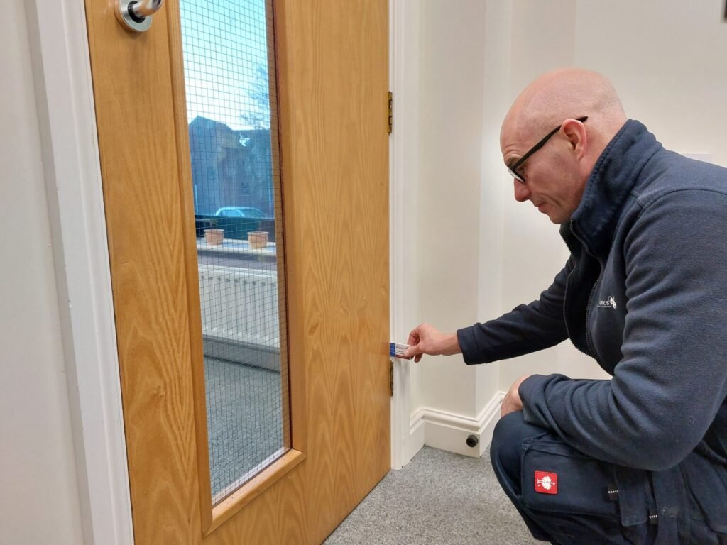 Self-closing device on a fire door being checked