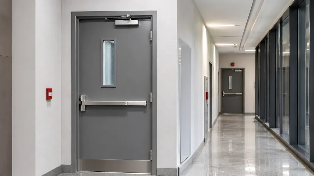 Inspector checking a fire door and its gaps in a communal corridor